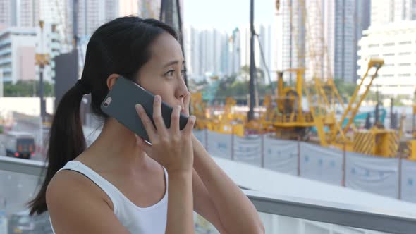 Woman talk to cellphone disturb by construction site 