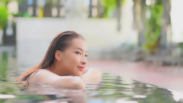 Young asian woman enjoy around outdoor swimming pool for leisure