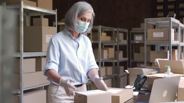 Female Manager and Courier Wearing Face Masks Working in Warehouse