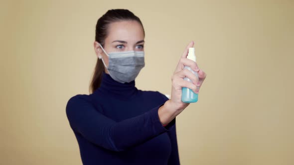 Woman in Protective Mask Sprays Disinfectant Into Air, Focus on Disinfectant