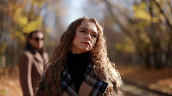 Woman is Leaving Her Exboyfriend in Park in Autumn Day Walking Away Breakup of Loving Couple