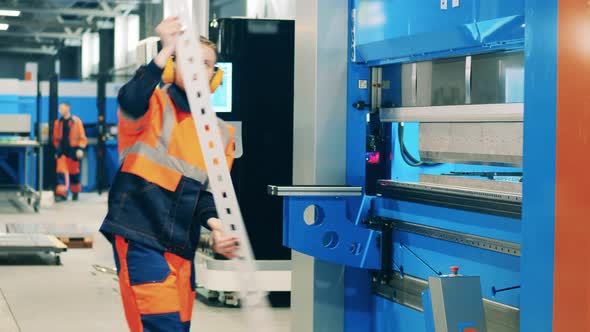 Female Worker Placing Aluminum Part Into a Machine