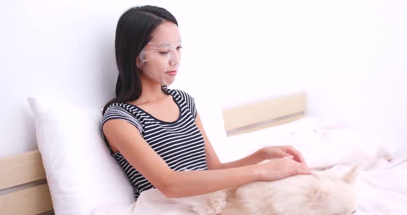 Woman apply paper mask and touch on her dog