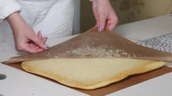 A Woman Removes A Non Stick Mat From A Freshly Baked Biscuit.