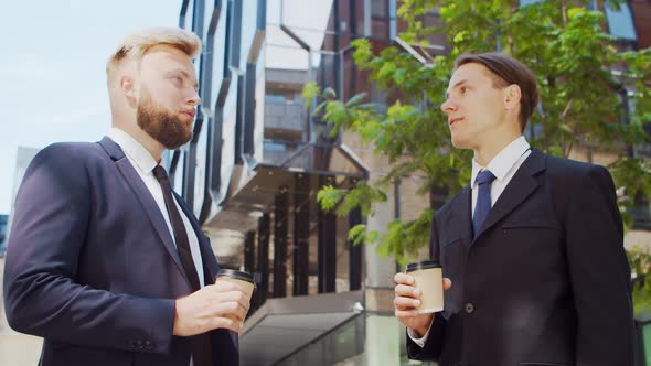 Confident businessman and his colleague in front of modern office building.