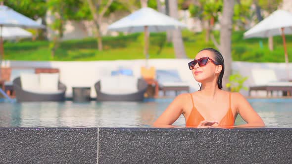 Young asian woman enjoy around outdoor swimming pool for leisure