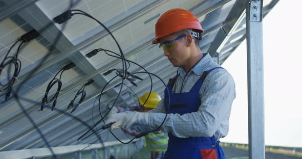 Workers Connecting Wires of Solar Panels