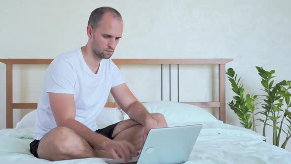 Happy Man Celebrating Success, Gesturing and Shouting, Working on Laptop in Bedroom