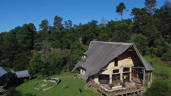 Drone shot of an eco farm in Hogsback, South Africa - drone is flying over the wooden guesthouse. Sn