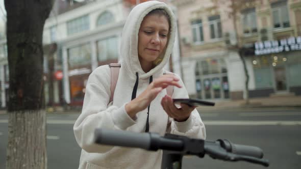 Woman Take Electric Kick Scooter Or Bike Bicycle In Sharing Parking Lot