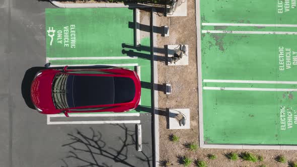 Drone Raising Up Above Modern Red Electric Vehicle Aerial Electric Car Driving alt