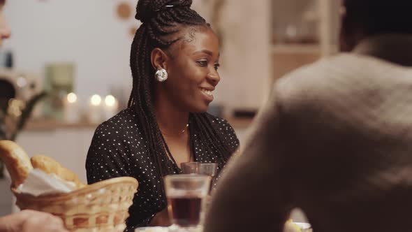 Young Afro-American Woman Chatting with Friends and Posing for Camera at Dinner