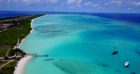 Wide angle aerial tourism shot of a summer white paradise sand beach and aqua blue water background 