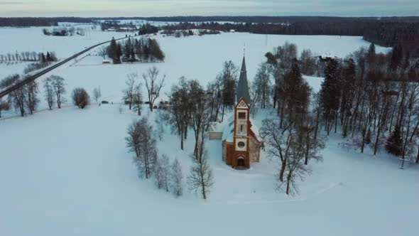 Aerial Top View of the Krimulda Evangelic Lutheran Church in Winter at Sunrise Latvia 4k Video