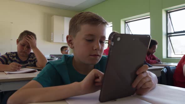 Boy using digital tablet in the class