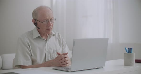 Aged Man Is Using Video Call on Notebook, Sitting at Home, for Communication with Colleagues, Self