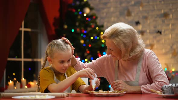 Excited Girl Decorating Xmas Cookies With Granny, Family Festive Traditions