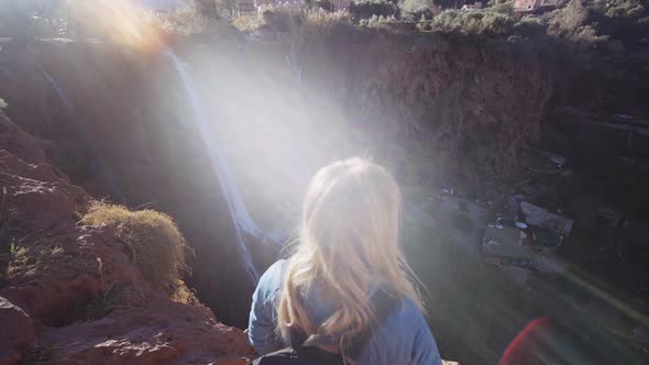 Tourist On Cliff Edge In Sunlight By Ouzoud Falls