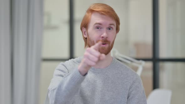 Portrait of Young Redhead Man Pointing and Inviting