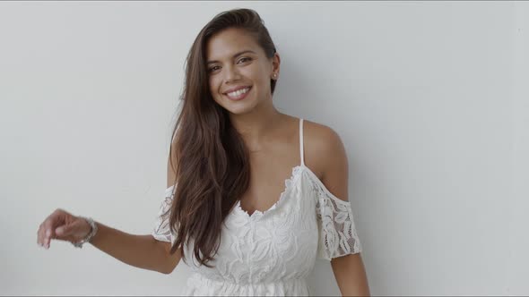 Happy Young Woman in White Dress Looking at Camera