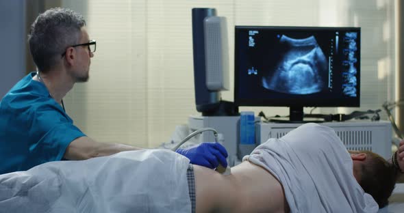 Doctor Examining Man with Ultrasound