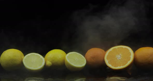 Tropical Lemon and Orange in Cold Ice Clouds of Fog Smoke on Black Background
