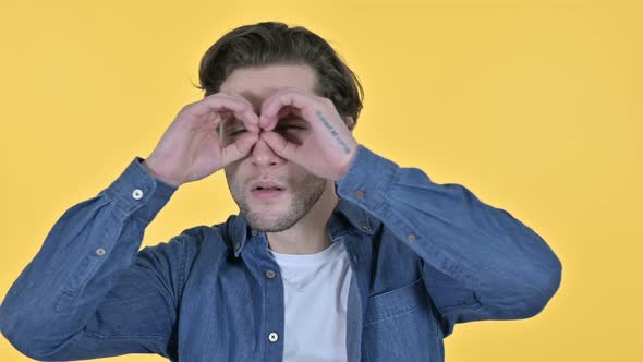 Young Man Searching for Opportunities on Yellow Background