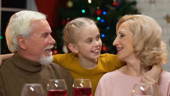 Grandparents Kissing Cute Granddaughter, Old Couple Happy to See Child at Xmas