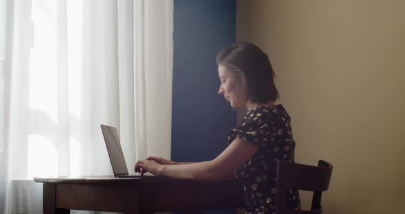 Happy Young Woman Typing on Laptop Using Computer Working on Internet