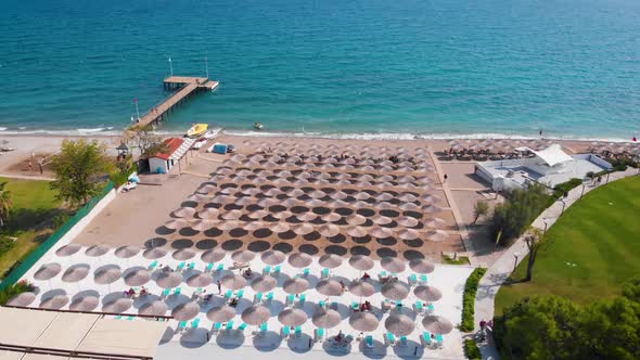 Flight Over the Beach with Umbrellas Towards the Pool in a Luxury Hotel