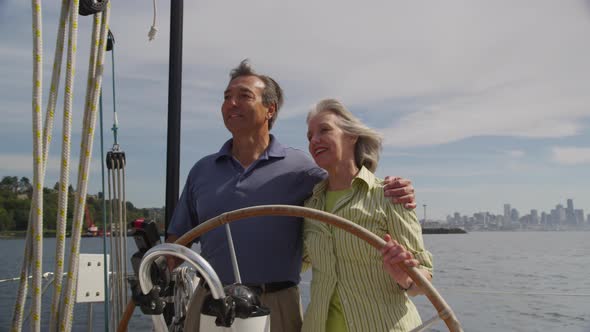 Senior couple behind the wheel of sailboat together. Shot on RED EPIC for high quality 4K, UHD, Ultr