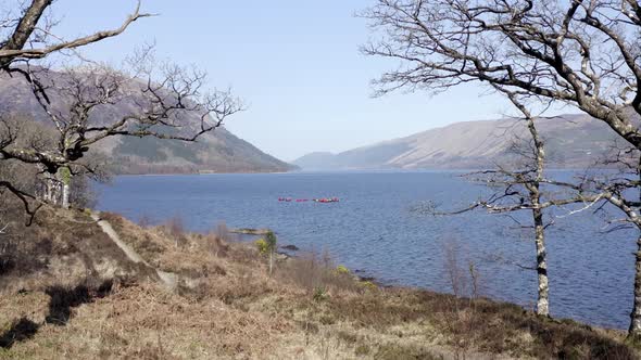 Canoeists in a Lake Surrounded by Forests and Mountains