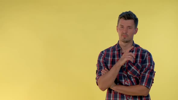 On Yellow Background Cheerful Tall Boy Making a Hush Gesture