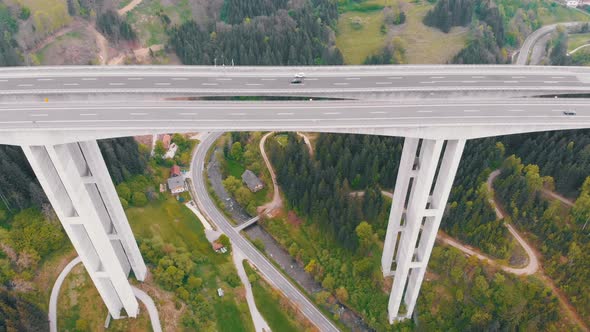 Aerial View of the Highway Viaduct on Concrete Pillars with Traffic in Mountains