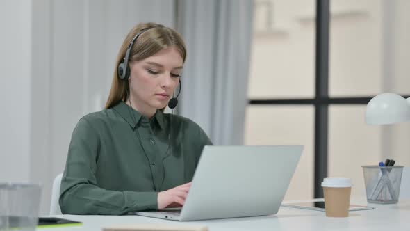 Young Woman with Headset Working on Laptop