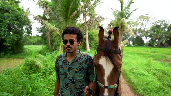 Young handsome man with brown horse.