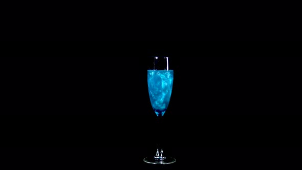 Glass with Blue Liquid. The Elixir Spins and Overflows with Liquid. Potion of Love Is Isolated on a