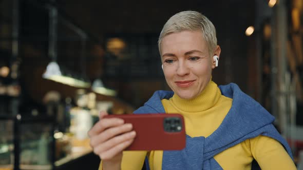 Middle Aged Woman Using Mobile for Video Call at Cafe