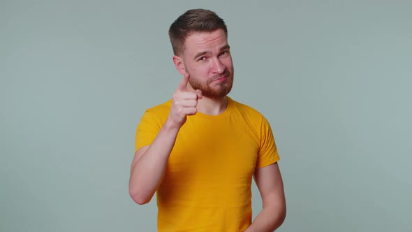 Cheerful One Man in Tshirt Looking at Camera Doing Phone Gesture Like Says Hey you Call Me Back