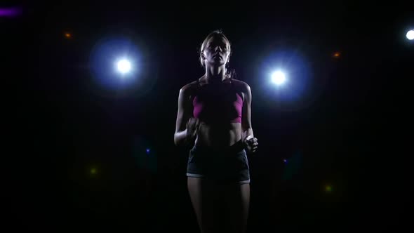 Approaching Shooting Running Girl Backlit on Black Background, Slow Motion, Close Up