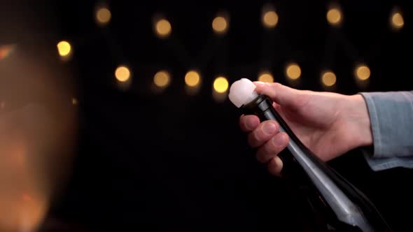 Foamy Champagne Pouring Out of the Bottle in Slow Motion. Hand Holds a Bottle of Pouring Champagne