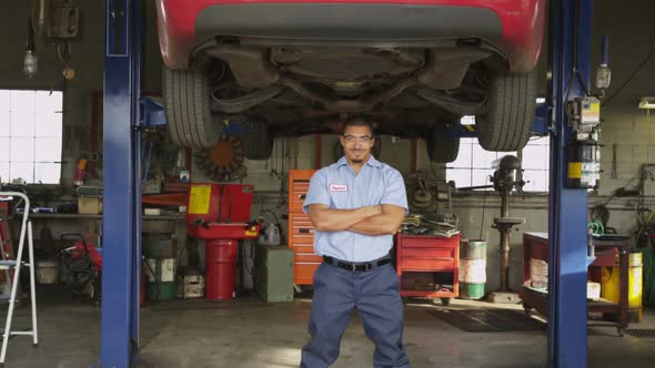 Portrait of auto mechanic standing in shop