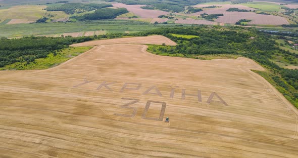 A Tractor Plowed An Inscription Dedicated To The Independence Day Of Ukraine On A Wheat Field