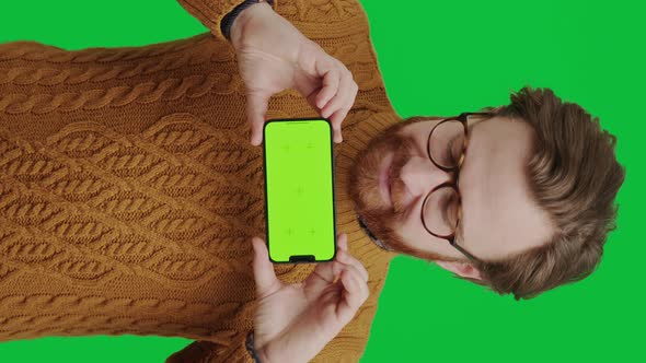 Vertical Shot Young Caucasian Entrepreneur Holding His Mockup Green Screen Smartphone and Grinning