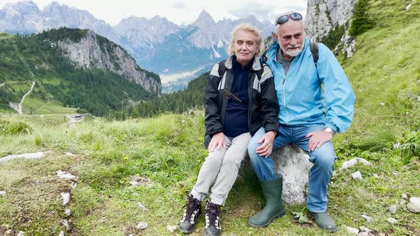 Elderly Couple Relaxing During a Mountain Excursion in the Alps Summer Season