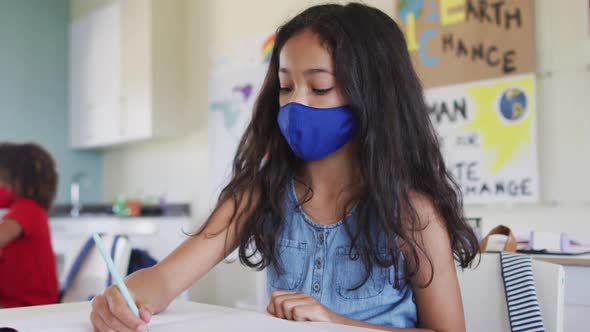 Girl wearing face mask sneezing in class at school