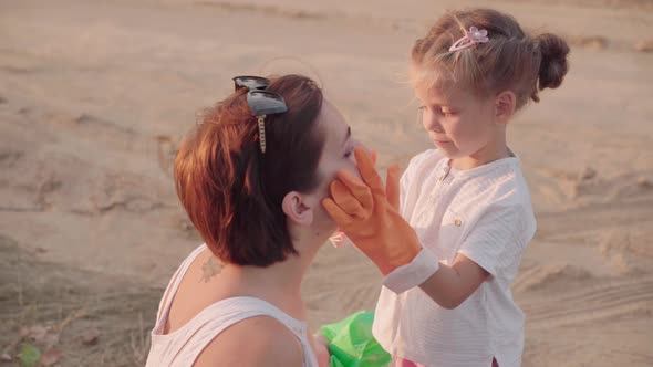 Little Girl Put on Gloves to Helps Mother Collects Plastic Garbage on Nature to Save Environment