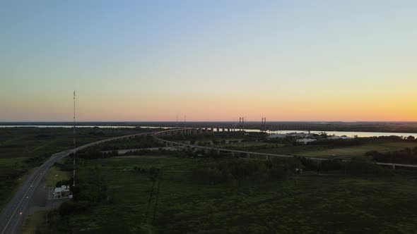 Aerial dolly right of Zarate Brazo Largo bridge on the distance at sunset
