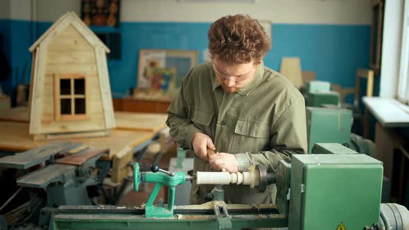 Carpenter Working with Machine in Workshop