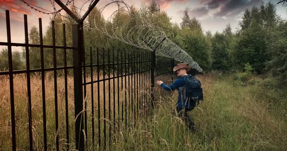 Man Runs to the Fence with Barbed Wire and Climbs on It